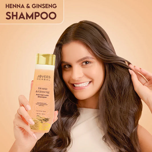 Jovees Henna & Ginseng Anti Hair Loss Shampoo bottle held by a smiling woman with shiny hair.