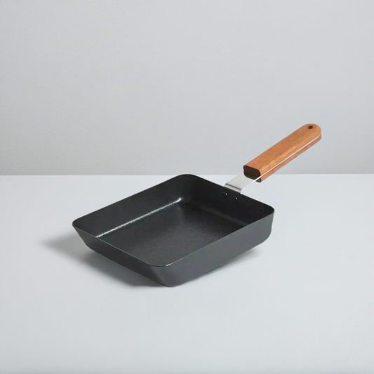 Square pan with non-stick surface and wooden handle.